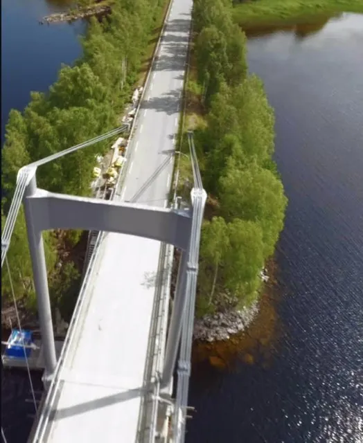 FPV-drone som stuper forbi tårnet på en hengebru over et vann
